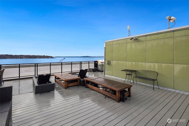 deck with outdoor lounge area and a water view