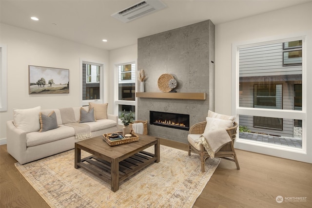 living room with hardwood / wood-style flooring and a tile fireplace