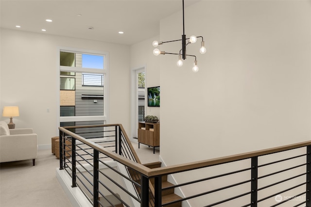 staircase featuring carpet floors and a chandelier