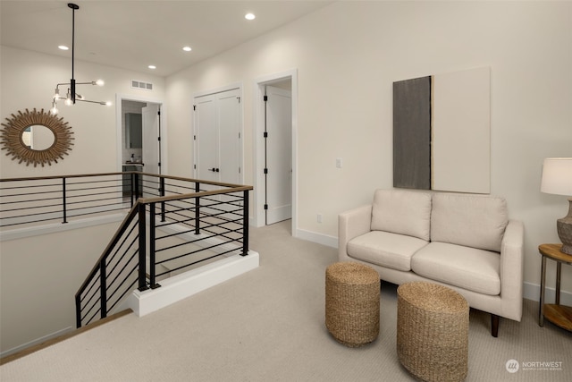 living area with light carpet and a notable chandelier