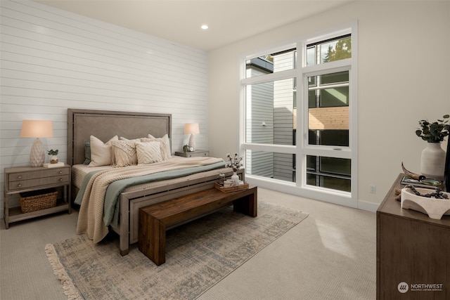 carpeted bedroom with wood walls