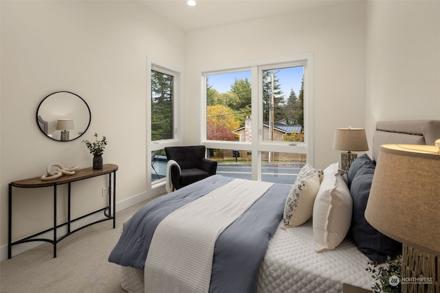 bedroom with multiple windows and light colored carpet