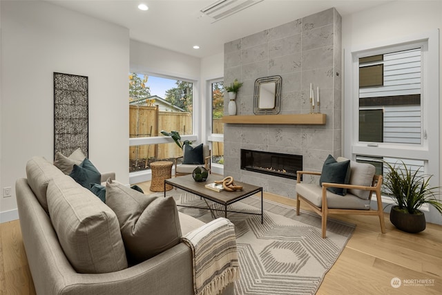 living room featuring hardwood / wood-style floors and a tiled fireplace