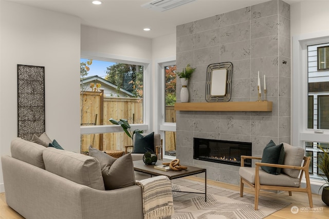 sitting room featuring hardwood / wood-style floors, a wealth of natural light, and a tile fireplace