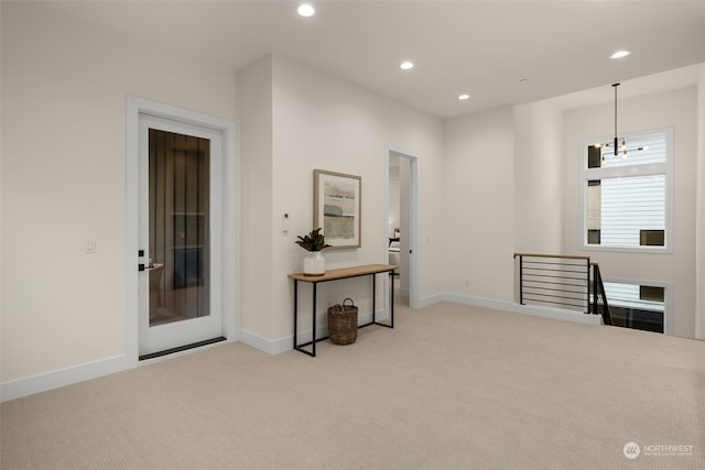 interior space with light colored carpet and an inviting chandelier