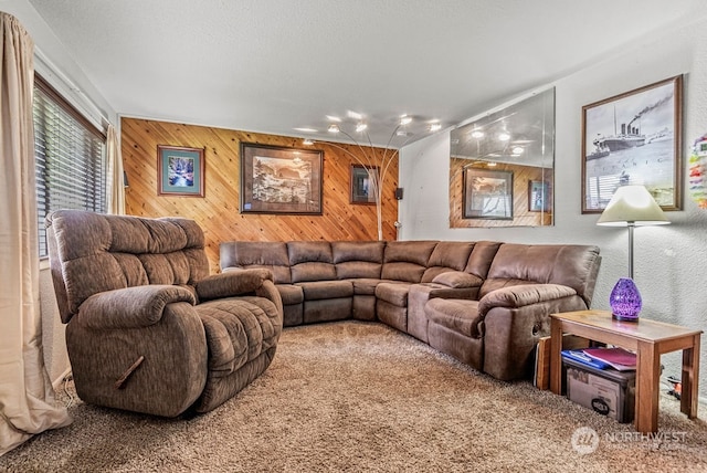 carpeted living room with wood walls