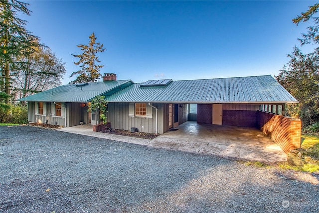 ranch-style home with a carport and solar panels