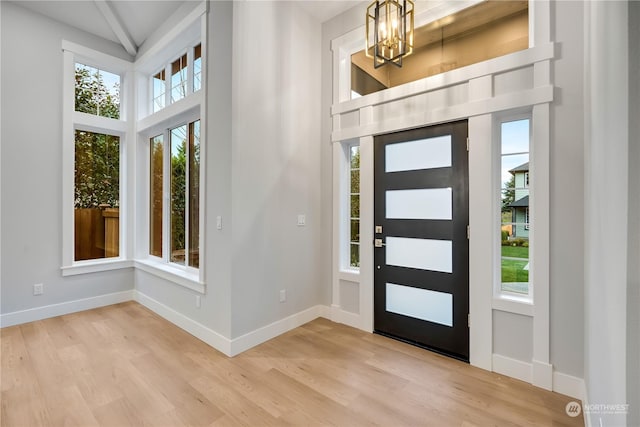 foyer featuring light wood-type flooring and an inviting chandelier