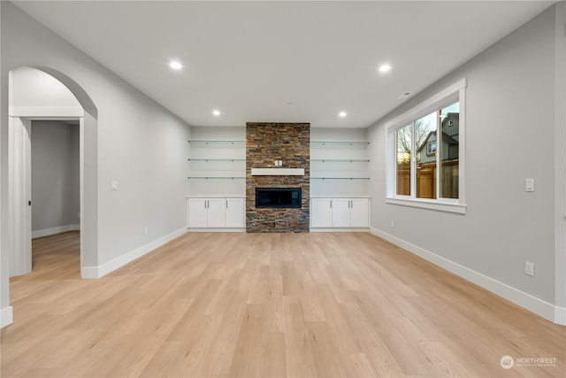 unfurnished living room with a fireplace and light hardwood / wood-style floors