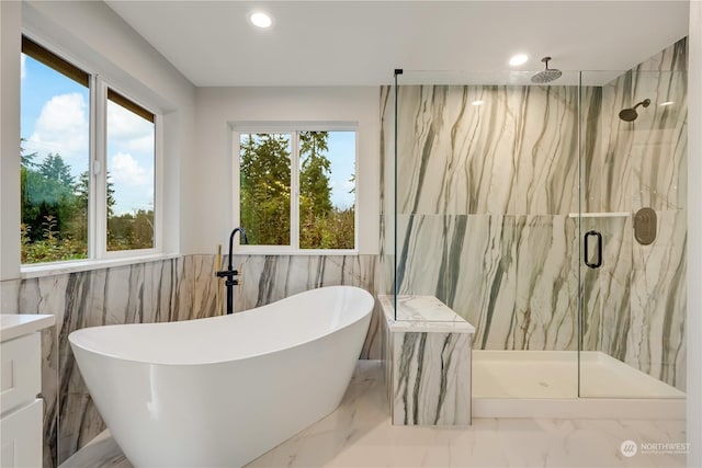 bathroom featuring plenty of natural light, separate shower and tub, and tile walls