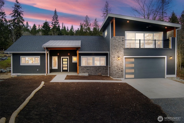 contemporary home with a garage and a balcony