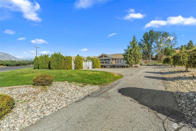 view of front of home with a mountain view and a front lawn