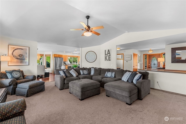 carpeted living room with ceiling fan and lofted ceiling