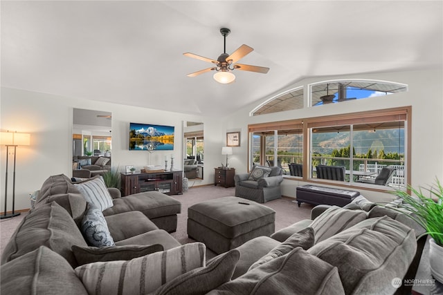 carpeted living room with ceiling fan and vaulted ceiling