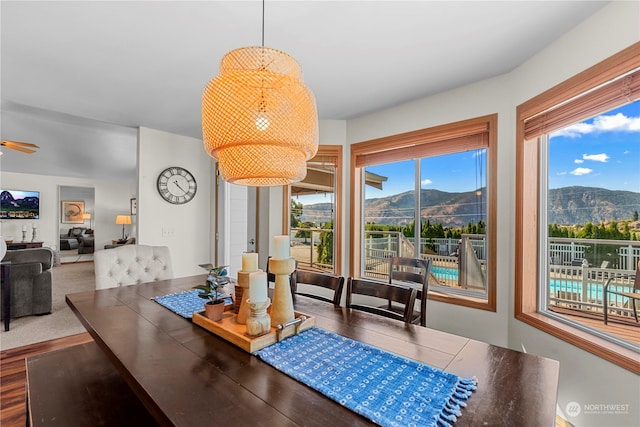 dining room featuring a mountain view, ceiling fan, and wood-type flooring