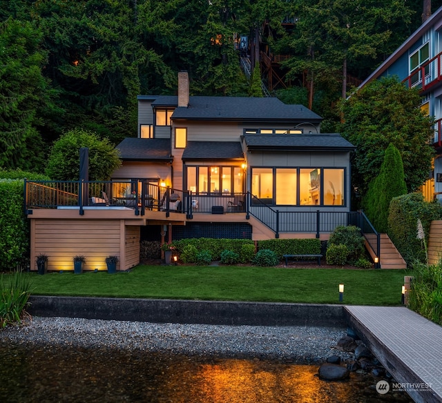 back of house featuring a sunroom, a yard, and a deck