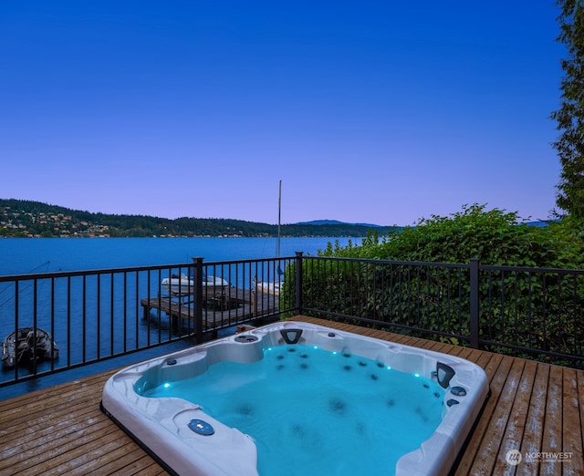 pool at dusk featuring a water view