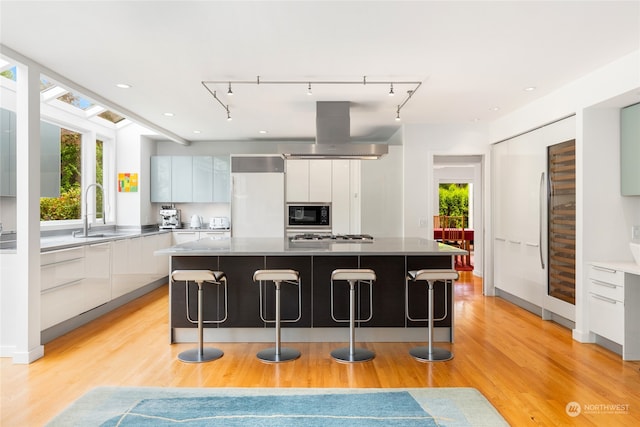 kitchen featuring a healthy amount of sunlight, white cabinetry, and a large island