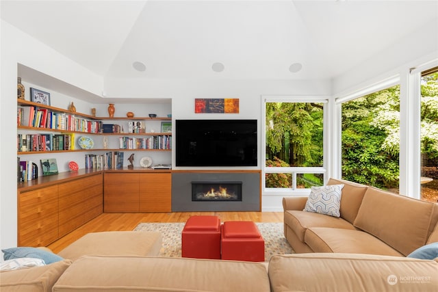 living room with light wood-type flooring and vaulted ceiling