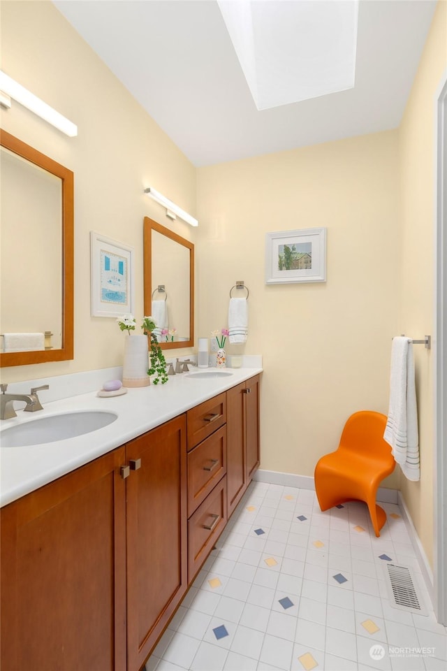 7842 NE 10th St, Medina, WA 98039 - bathroom featuring a skylight, double vanity, tile patterned floors, and baseboards