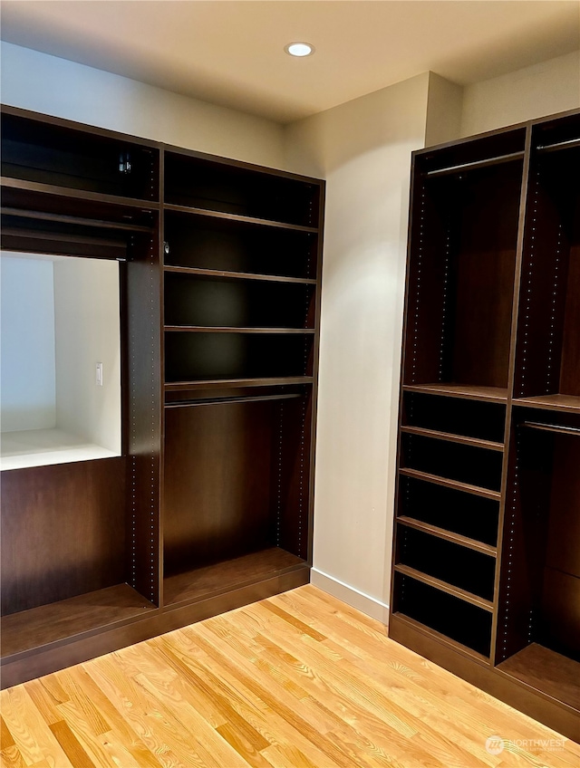 walk in closet with hardwood / wood-style flooring