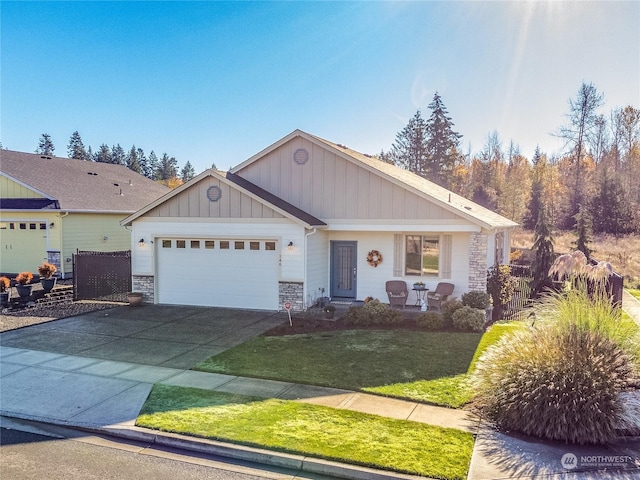 146 Zephyr Dr, Silverlake, WA 98645 - view of front of property featuring stone siding, an attached garage, a front yard, driveway, and board and batten siding