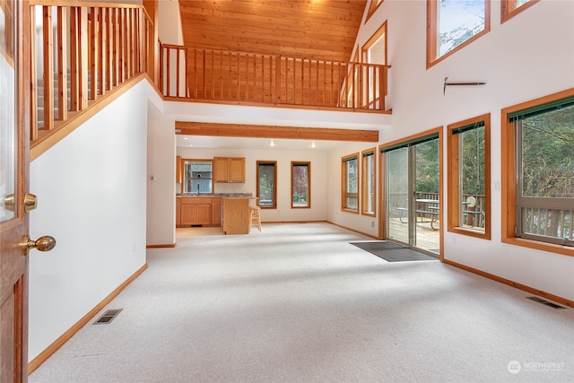 unfurnished living room featuring light carpet, high vaulted ceiling, and wooden ceiling