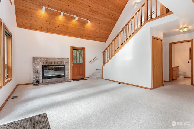 unfurnished living room with carpet floors, wooden ceiling, and track lighting