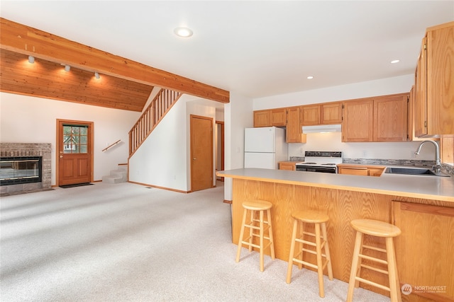 kitchen with beam ceiling, sink, kitchen peninsula, light colored carpet, and white appliances