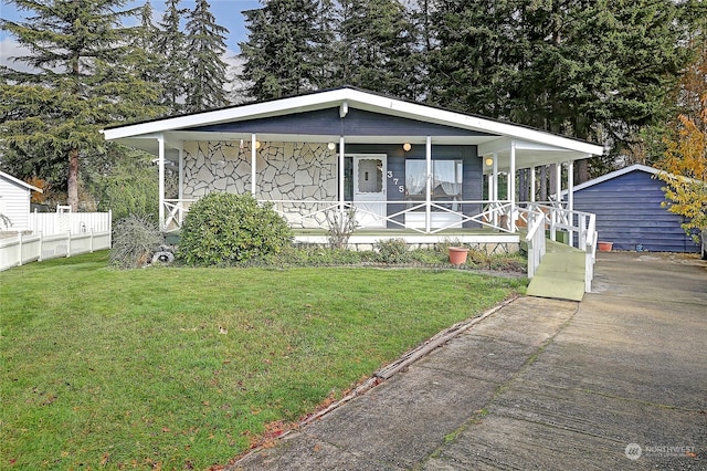 view of front of home with a front yard, a porch, and an outdoor structure