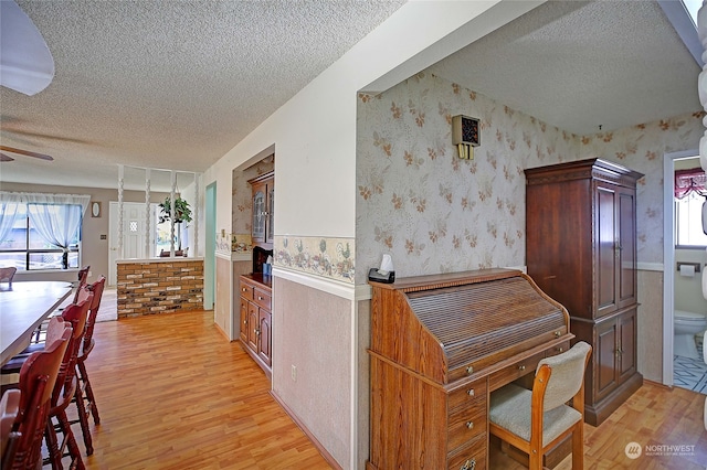 kitchen featuring ceiling fan, light hardwood / wood-style floors, and a textured ceiling