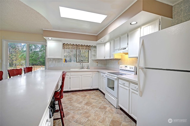 kitchen featuring plenty of natural light, white cabinetry, white appliances, and sink