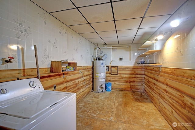 clothes washing area featuring water heater, tile walls, and washer / dryer