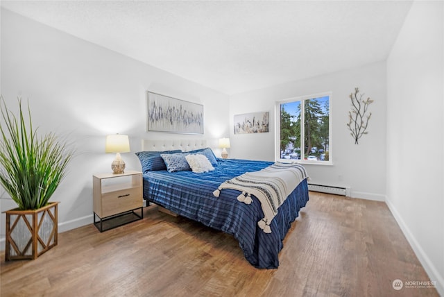 bedroom with hardwood / wood-style flooring and a baseboard radiator