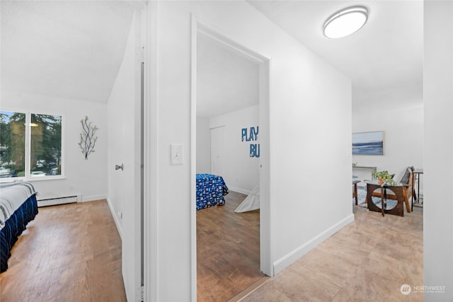 bedroom featuring light hardwood / wood-style flooring and a baseboard heating unit