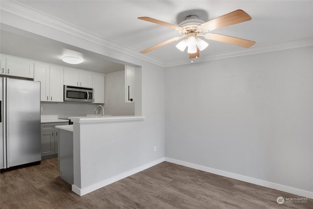 kitchen with white cabinetry, crown molding, dark hardwood / wood-style floors, and appliances with stainless steel finishes