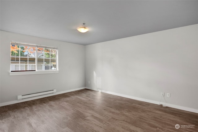 empty room featuring dark hardwood / wood-style flooring and baseboard heating