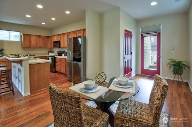 kitchen featuring appliances with stainless steel finishes, dark hardwood / wood-style floors, a center island, and a kitchen bar