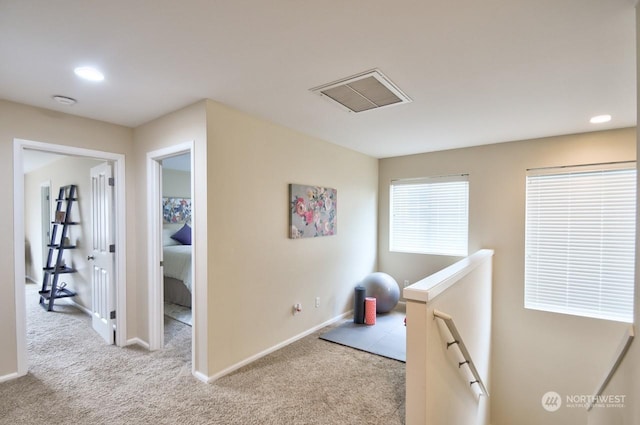 hall with light colored carpet