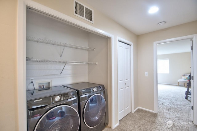 clothes washing area featuring light colored carpet and separate washer and dryer