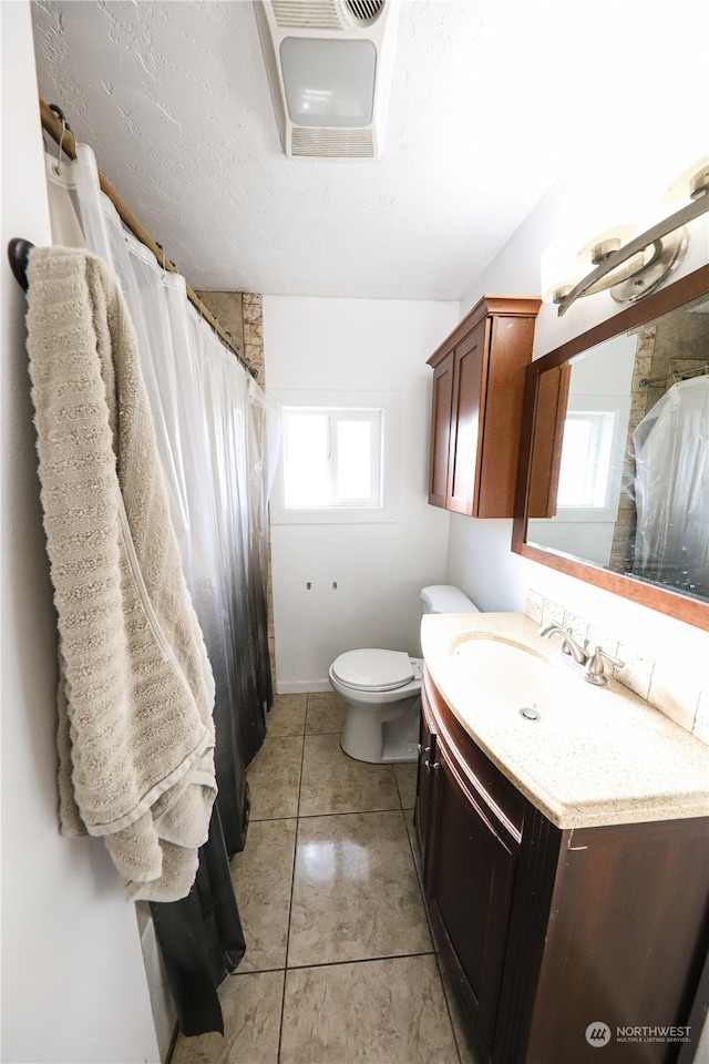 bathroom featuring tile patterned floors, vanity, and toilet