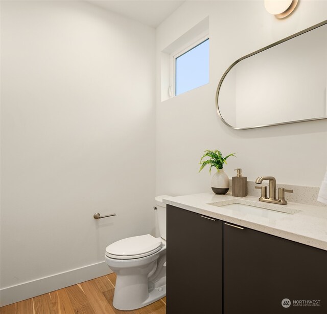 bathroom featuring hardwood / wood-style floors, vanity, and toilet