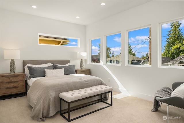 bedroom with multiple windows and light colored carpet