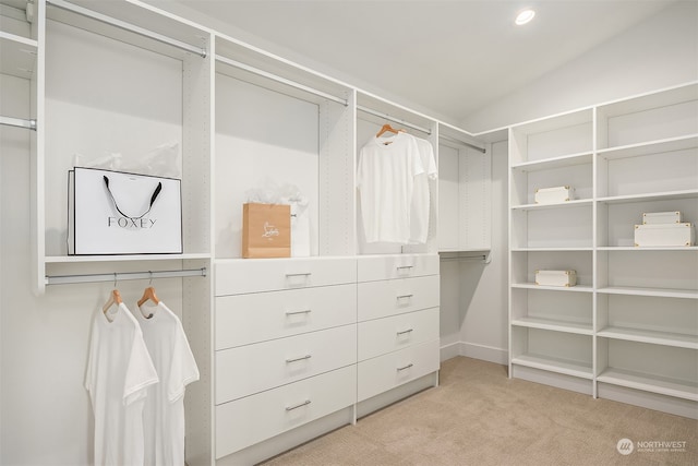 spacious closet featuring light colored carpet and lofted ceiling