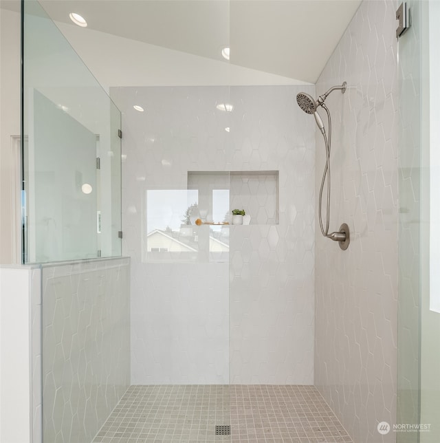 bathroom with a tile shower and vaulted ceiling