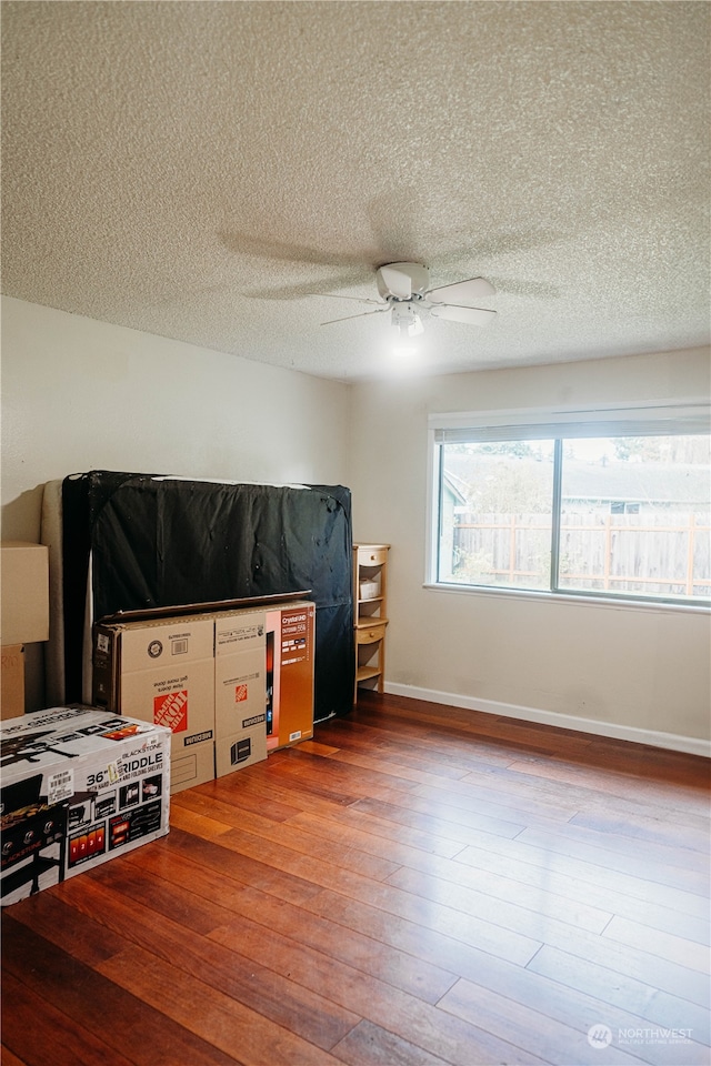 bedroom featuring hardwood / wood-style floors, ceiling fan, and a textured ceiling