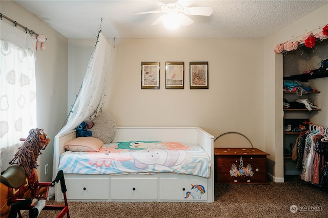 bedroom with carpet flooring, ceiling fan, and a textured ceiling