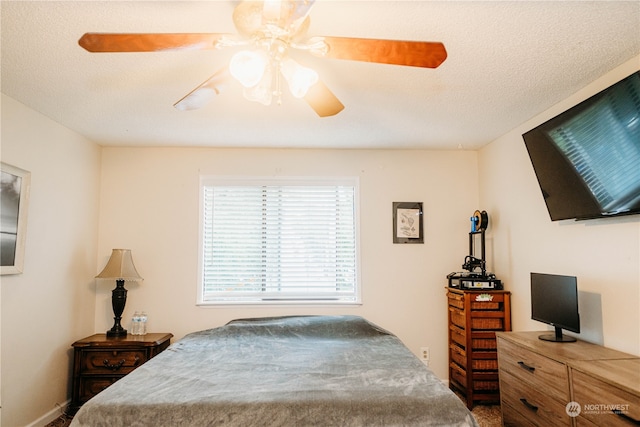 bedroom with ceiling fan and a textured ceiling