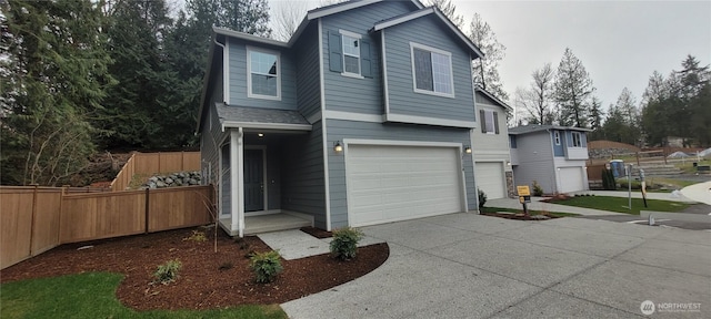 traditional-style home with an attached garage, driveway, and fence