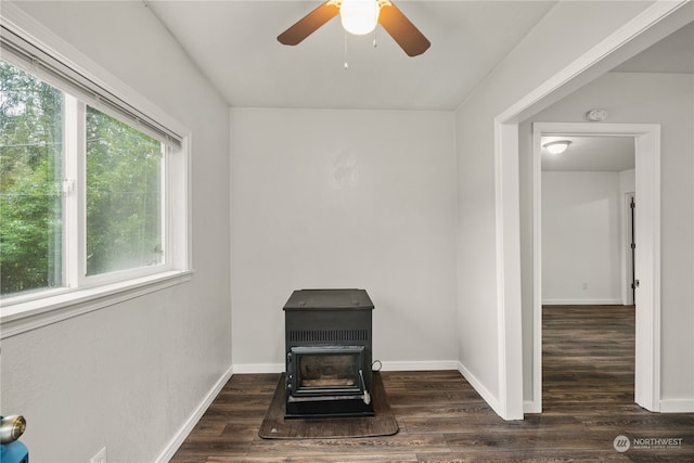 interior space with a wood stove, ceiling fan, and hardwood / wood-style flooring